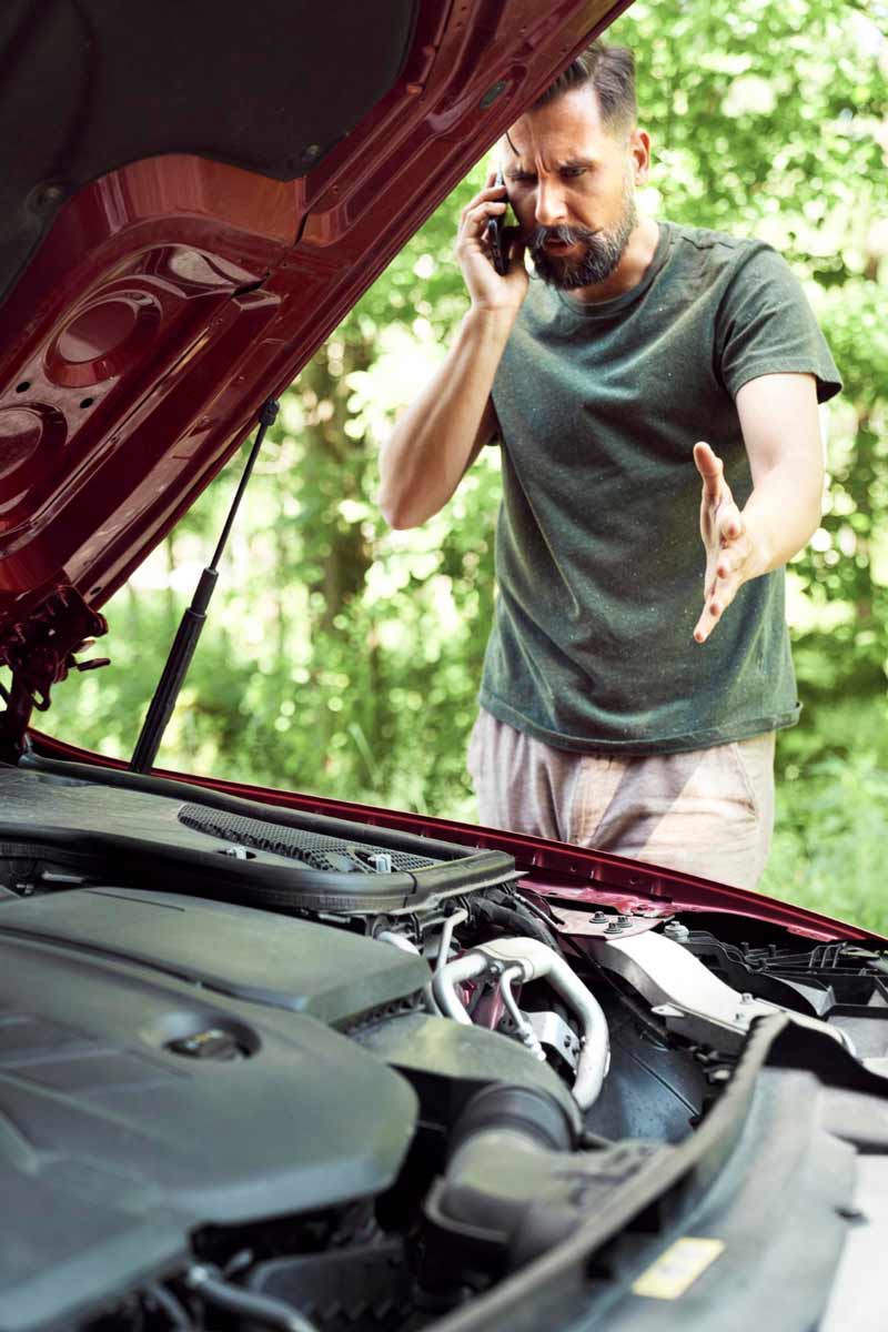 Junger Mann prüft Getriebeschaden bei Schrottauto Ankauf Schwelm